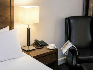 a hotel room with a bed and a chair and a phone at Mercure Haydock Hotel in Haydock +47 photos