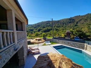 a house with a swimming pool next to a mountain at SOUTELO House in Grovelas
