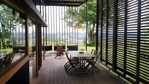 Habitación con mesa y sillas en una terraza. en Gite Dilos, en Rébénacq 8 fotos más