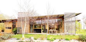 una casa de madera con una mesa delante en Gite Dilos, en Rébénacq