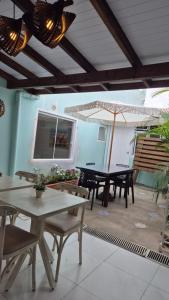 Un patio con mesas y sillas y una sombrilla. en Pérola de Bombinhas, en Bombinhas 65 fotos más