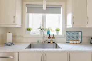a kitchen with a sink and a window at Inspired Stay close to Niagara *4B & 2King Beds* in Thorold +114 photos