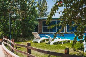 a yard with two chairs and a swimming pool at Muzdan Holiday homes in Unayzah