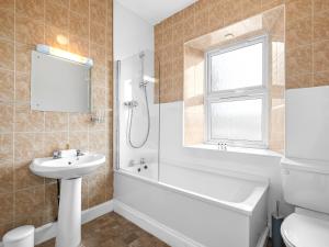 a bathroom with a sink and a tub and a toilet at No. 1 Charlotte Street in Port Ellen +74 photos