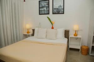 a bedroom with a bed with white sheets and pillows at Water's Edge Villa Ahangama in Ahangama