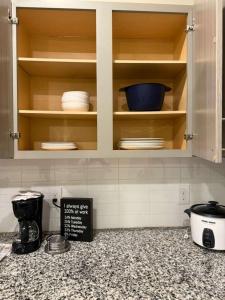 a kitchen with wooden cabinets with plates and bowls at Great place to Relax and Shopping in Cedar Park +2 photos