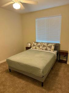 a bedroom with a bed with a ceiling fan and a window at Great place to Relax and Shopping in Cedar Park