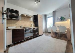 a kitchen with stainless steel appliances and a table and chairs at Chillout Apart pod Górą Zamkową in Wleń