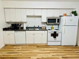 a kitchen with white cabinets and a white refrigerator at Short North Convention King Bed Free Parking! in Columbus