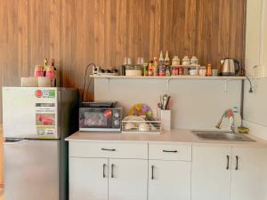 a kitchen with white cabinets and a refrigerator and a sink at Amy Hotel & Apartment in Da Thanh