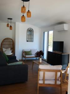 a living room with a couch and a tv at Loc' Maria - Grands Sables in Groix
