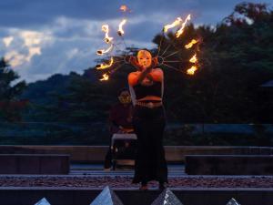a woman standing with fire torches in her hands at Avista Hideaway Phuket Patong - MGallery in Patong Beach