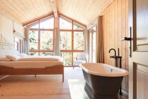 a bedroom with a tub and a bed and a window at STUBN in der Frasdorfer Hütte in Frasdorf