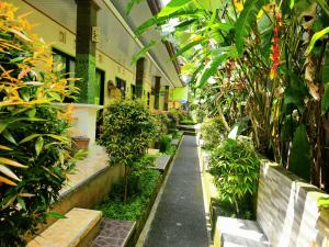 a corridor of a building with plants and benches at green view downtown in Ubud