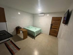 a small room with a bed and a wooden door at Conforto e Tranquilidade - Excelente Estadia in Recife