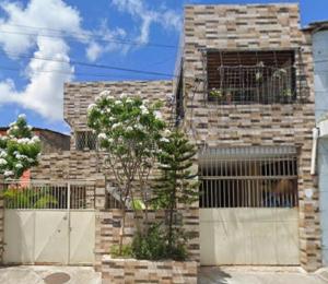 una casa in mattoni con cancello e albero di Conforto e Tranquilidade - Excelente Estadia a Recife