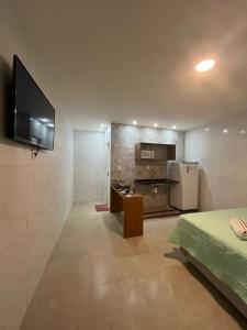 un soggiorno con TV e cucina di Conforto e Tranquilidade - Excelente Estadia a Recife