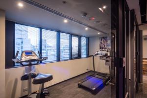 a room with a gym with a treadmill and windows at Goldinn Hotel in Taipei