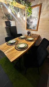a wooden table with chairs and plates on it at Forest hugs котедж Славсько in Khashchovanoye