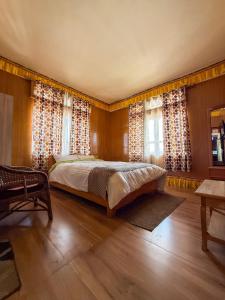 a bedroom with a bed and two windows at JD House in Tawang