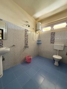 a bathroom with a toilet and a sink at JD House in Tawang +7 photos