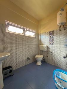 a bathroom with a toilet and a sink at JD House in Tawang
