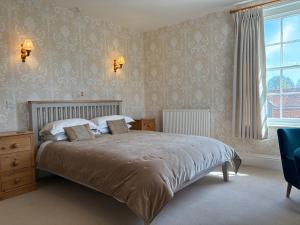 un dormitorio con una cama y una ventana en Lower Bryanston Farm, en Blandford Forum