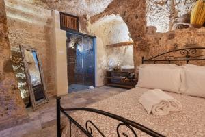 ファザーノにあるMasseria Torre Rossaの石の壁の中にベッドが置かれた寝室
