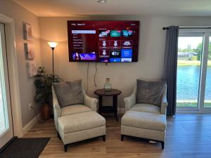 ボニータ・スプリングスにあるOctopus Perfect Location On Pond 3 Mile To Gulf Beachのリビングルーム(椅子2脚、薄型テレビ付)