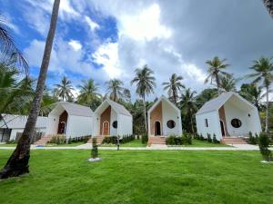 Ban Bang BaoにあるDe coco villa kohkood V2のヤシの木のある3つの白い建物のグループ