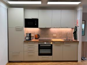a kitchen with stainless steel appliances and white cabinets at Ferienwohnung Nähe Zollverein Essen in Essen +6 photos
