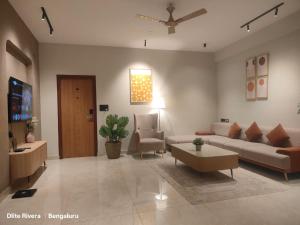 a living room with a couch and a table at Dlite Rivera Luxury Service Apartments in Bengaluru