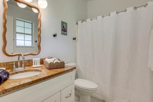 a bathroom with a sink and a toilet and a mirror at Less Than 1 Mi to Butler Beach! Home with Backyard Oasis in Butler Beach +18 photos