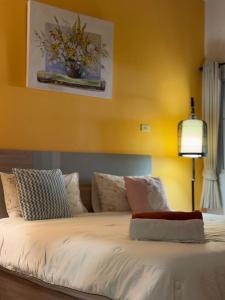 a bedroom with a bed with a yellow wall at Ao-Nang Private Red House 10 in Ao Nang Beach