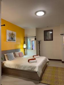a bedroom with a large bed with yellow walls at Ao-Nang Private Red House 10 in Ao Nang Beach