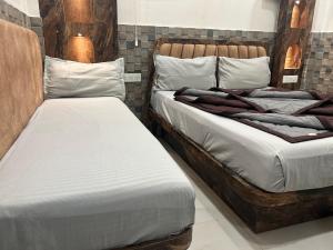 two beds sitting next to each other in a room at Shree Guru Guest House 3 Minutes Walking Distance From New Delhi Railway Station in New Delhi