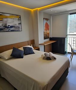 a bedroom with a large bed with blue pillows at Lofts | Consolação | 3 min Metrô in Sao Paulo