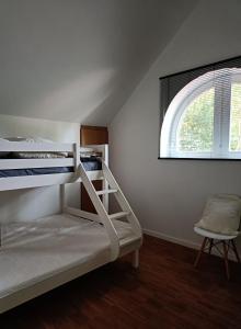 a white bunk bed in a room with a window at De Steeg in Kalmthout
