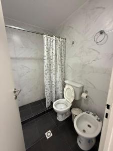 a white bathroom with a toilet and a sink at Apartamentos La Posta in San Salvador de Jujuy +20 photos