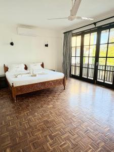 a bedroom with a bed and large windows at Wayside Beach Apartments in Diani Beach +83 photos