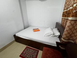 Cama pequeña en habitación con cortina en Hotel Tayef Dhanmondi, en Dhaka 19 fotos más