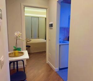een kleine keuken met een tafel en een kamer met een bed bij Appartme Stampa 2 in Milaan