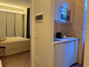 een kamer met een bed en een keuken met een magnetron bij Appartme Stampa 2 in Milaan