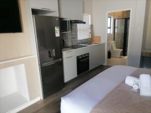 Una cocina con un refrigerador negro y un fregadero. en Going Places Bed and Breakfast Queenstown, en Queenstown