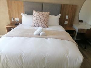 Una cama blanca grande con dos toallas encima. en Going Places Bed and Breakfast Queenstown, en Queenstown