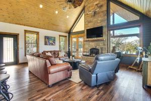 ein Wohnzimmer mit Ledermöbeln und einem Steinkamin in der Unterkunft Upscale A-Frame Escape with Lake Access in Quinton! in Carlton Landing