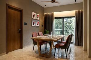a dining room with a wooden table and chairs at Dlite Rivera Luxury Service Apartments in Bengaluru +7 photos