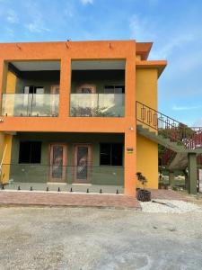 a large orange building with a balcony and two doors at Louise's Hideaway in Black River +3 photos