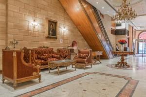 a lobby with couches and chairs in a building at Om Kolthoom Hotel in Cairo