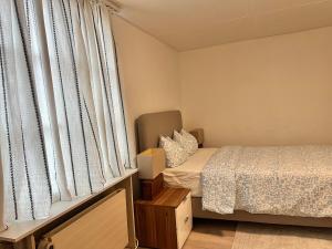 a small bedroom with a bed and a window at Newly Renovated Stylish & Spacious Studio in Huttwil